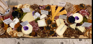 cheese and charcuterie board with assorted cheeses, breads and meats. 