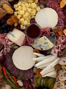 cheese and charcuterie board with assorted cheeses, breads and meats. 