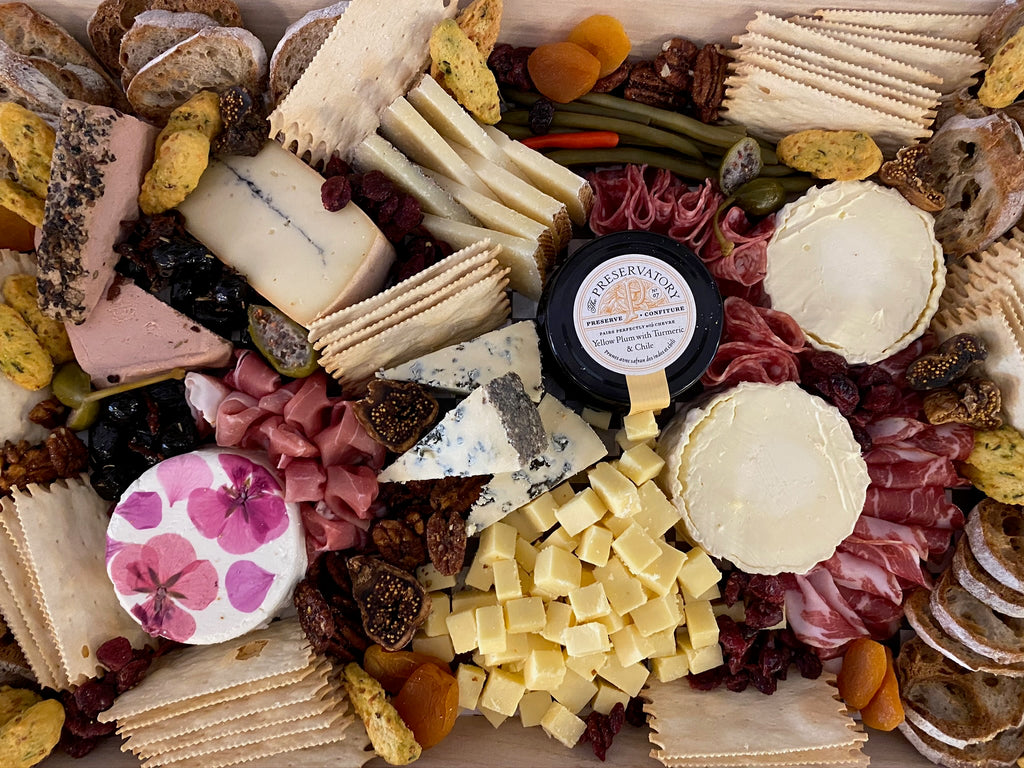 cheese and charcuterie board with assorted cheeses, breads and meats. 