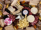 cheese and charcuterie board with assorted cheeses, breads and meats. 