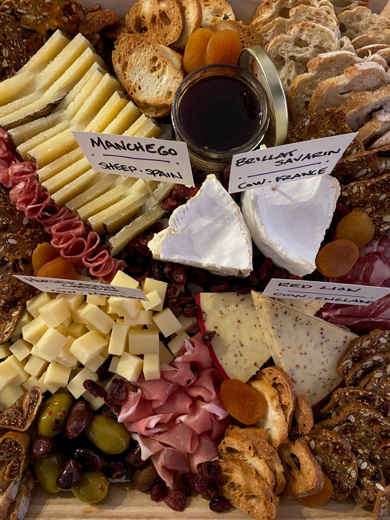 cheese and charcuterie board with assorted cheeses, breads and meats. 