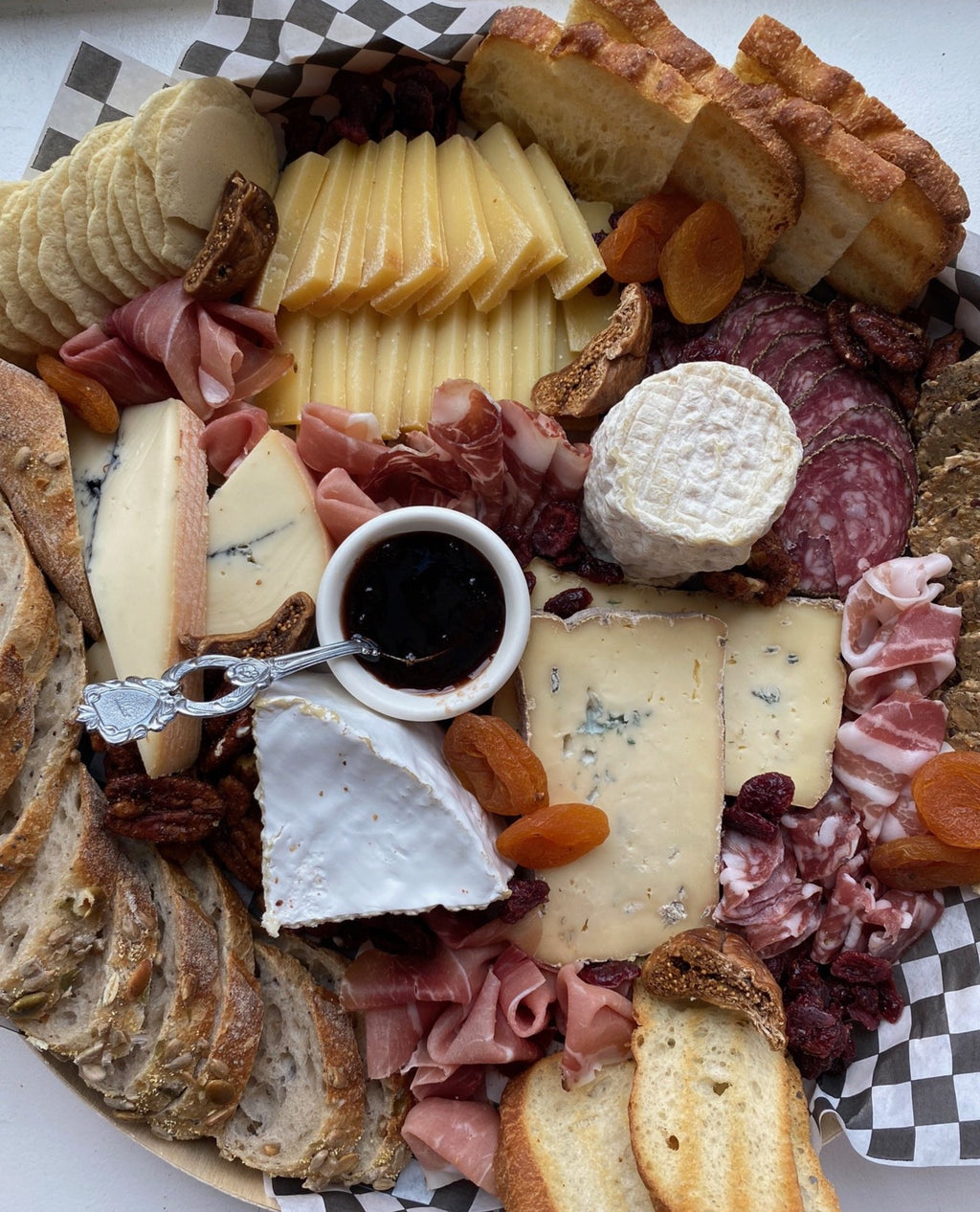 cheese and charcuterie board with assorted cheeses, breads and meats. 