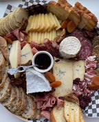 cheese and charcuterie board with assorted cheeses, breads and meats. 