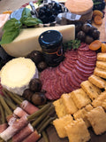cheese and charcuterie board with assorted cheeses, breads and meats. 