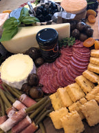 cheese and charcuterie board with assorted cheeses, breads and meats. 