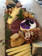 cheese and charcuterie board with assorted cheeses, breads and meats. 